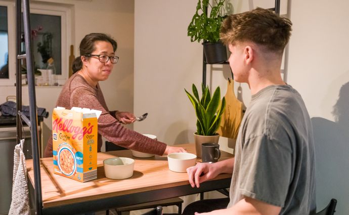 Open Homes Nottingham volunteer and young person sharing a healthy breakfast, illustrating the supportive daily life in the emergency accommodation.