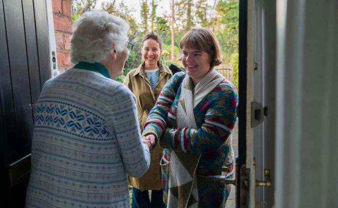 Warm and welcoming Open Homes Nottingham volunteers in a friendly conversation, representing the community's commitment to supporting homeless youth