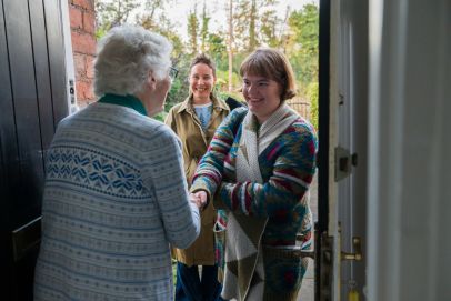 Warm and welcoming Open Homes Nottingham volunteers in a friendly conversation, representing the community's commitment to supporting homeless youth